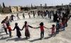 在叙利亚东部阿勒颇的乡村地区，学生们在一所受损学校的操场上玩耍。